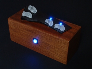 Battery powered with all working concealed in the mahogany base...